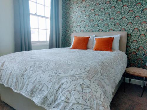 a bedroom with a large bed with orange pillows at Heavenly Outlook in Scarborough