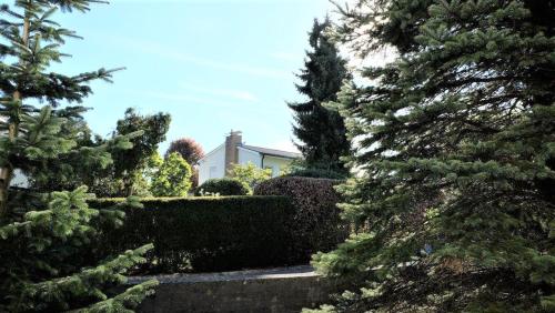 a house is seen through the trees in a garden at Ferienwohnung Kaiserblick in Stephanskirchen