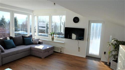 a living room with a couch and a tv at Ferienwohnung Kaiserblick in Stephanskirchen