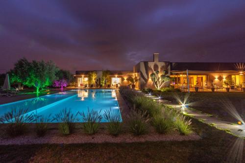 a house with a swimming pool at night at Villa Jardins D'Isa in Marrakech