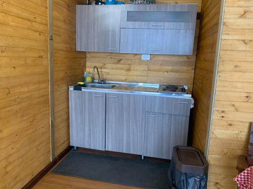 a small kitchen with a sink in a wooden wall at Mirador Bosque Gran Torino Neusa in Cogua