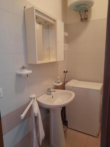 a white bathroom with a sink and a toilet at TERRAZZA SUL MARE in Marotta