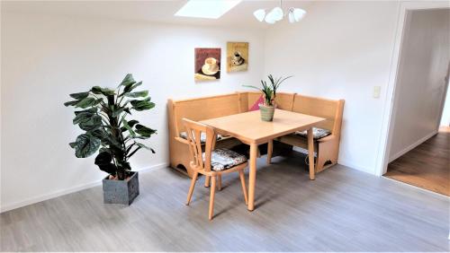 Un comedor con una mesa y una planta en maceta. en Ferienwohnung Kaiserblick, en Stephanskirchen