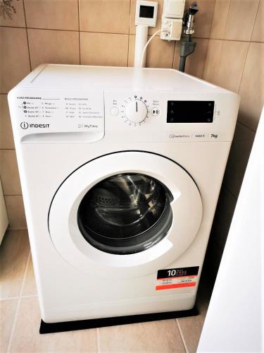 a white washing machine sitting in a bathroom at Ferienwohnung Kaiserblick in Stephanskirchen
