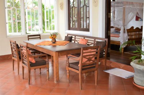 a dining room with a wooden table and chairs at Lanka Beach Boutique Bungalows & Grand Villa in Tangalle