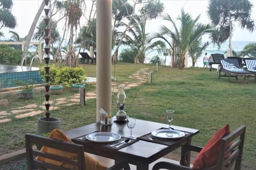 a table with two plates of food on top of a field at Lanka Beach Boutique Bungalows & Grand Villa in Tangalle
