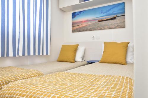 a bedroom with two beds and a painting on the wall at Retiro da Praia da Aguda in Arcozelo