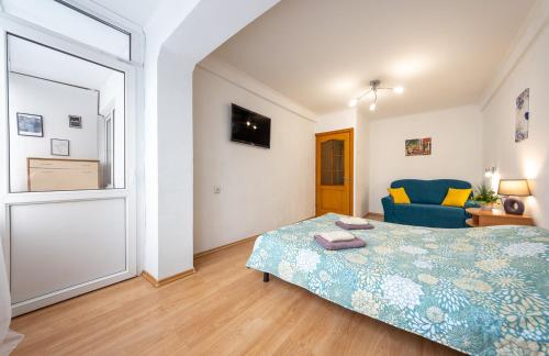 ein Schlafzimmer mit einem Bett und einem blauen Stuhl in der Unterkunft Уютная квартира на Оболонском проспекте у метро in Kiew