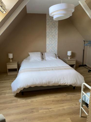 a bedroom with a white bed and two night stands at La Petite Maison in Saint-Nicolas-du-Pélem