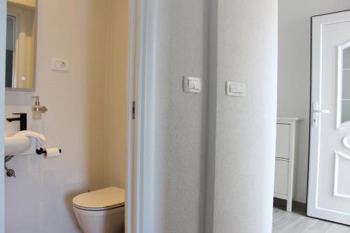 a bathroom with a toilet and a toilet paper dispenser at THE VIEW in Pučišća
