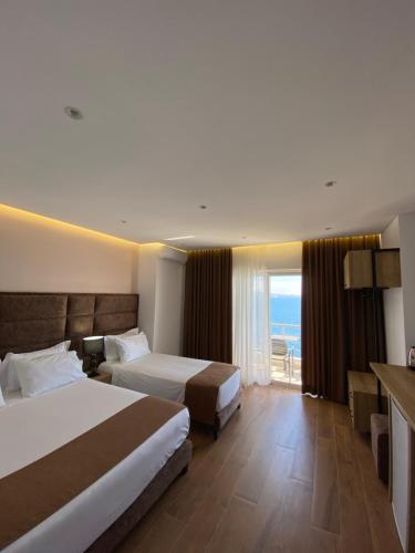 a hotel room with two beds and a view of the ocean at Hotel Erioni in Sarandë