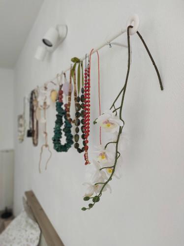 a row of beads and flowers hanging on a wall at Happy Home in Călimăneşti