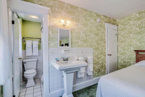 een witte badkamer met een wastafel en een toilet bij Atlantic Hotel, Inc in Ocean City