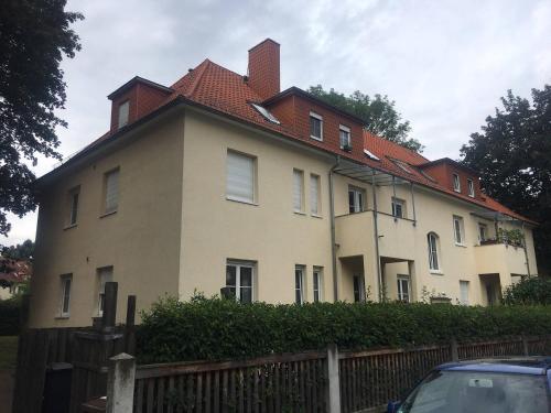 duży biały dom z czerwonym dachem w obiekcie Ferienwohnung Tapetenwechsel -Balkon- w Dreźnie