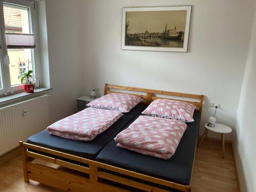 a bed with two pillows on it in a room at Ferienwohnung Tapetenwechsel -Balkon- in Dresden