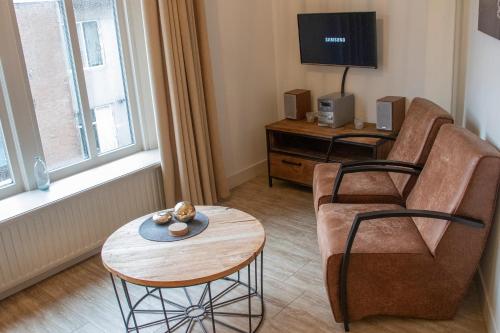 ドンブルグにあるKoetsementen appartementen met strandcabineのリビングルーム(ソファ、テーブル付)