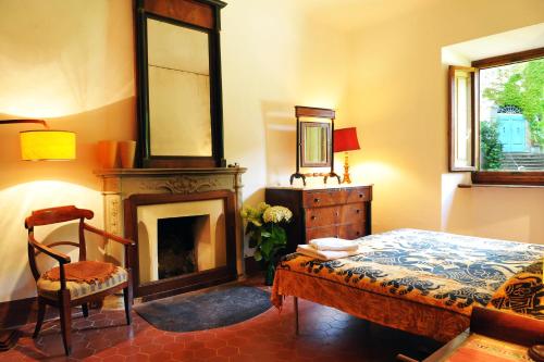 1 dormitorio con 1 cama, chimenea y silla en La Villa di Caiano, en Londa