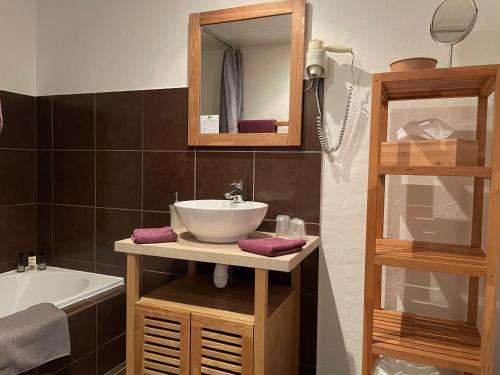 a bathroom with a sink and a mirror and a tub at Hotel L'Orangeraie in Le Lavandou