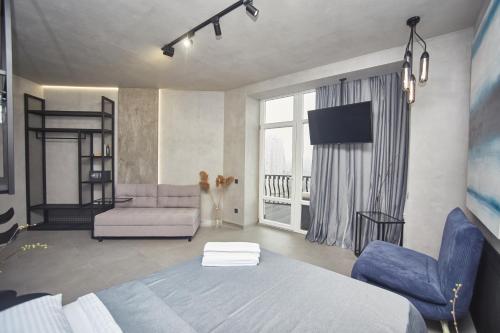 a bedroom with a bed and a couch and a tv at Stixiya in Odesa