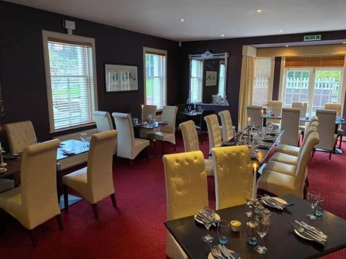 a dining room with tables and yellow chairs and tablesktop at The Castle Inn in Dirleton