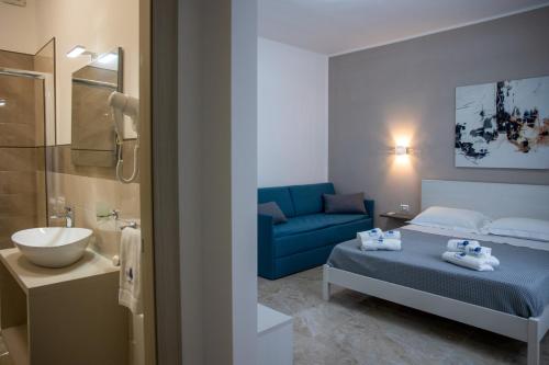 1 dormitorio con 1 cama azul y 1 sofá azul en B&B 3 Vele, en Porto Cesareo
