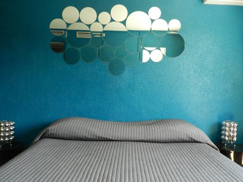 a bedroom with a bed with a blue wall at Hotel L'Orangeraie in Le Lavandou
