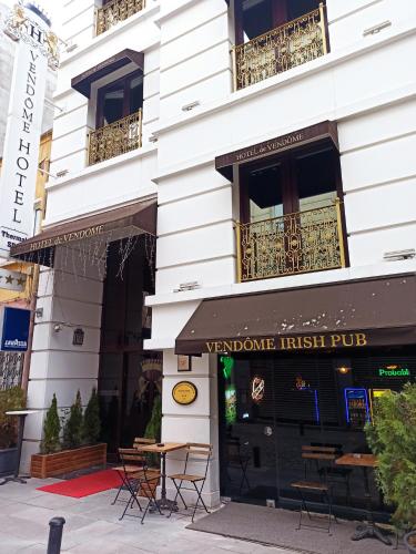 a building with tables and chairs in front of it at Vendome Hotel in Eskisehir