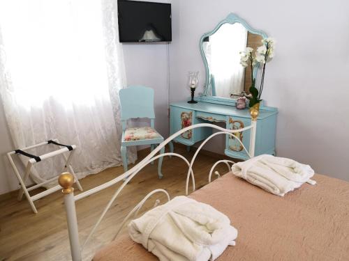 a bedroom with a bed and a mirror and a chair at Melissa Keros in Roussopoúlion