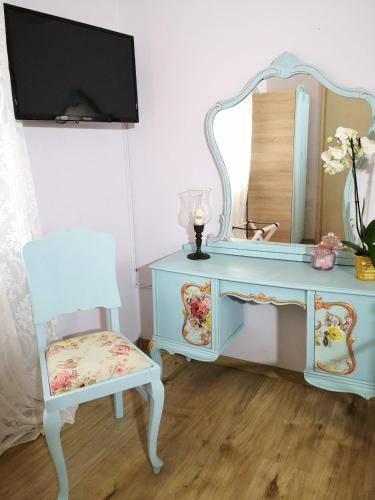 a blue dressing table with a chair and a mirror at Melissa Keros in Roussopoúlion