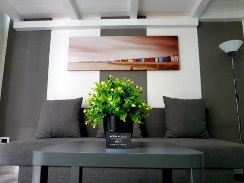 a table with a vase of flowers on top of a couch at room n.23 in Taranto