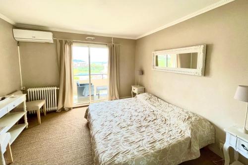 a small bedroom with a bed and a window at Hotel L'Orangeraie in Le Lavandou