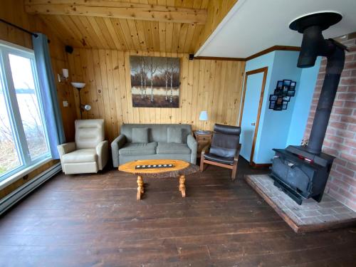 a living room with a couch and a wood stove at Auberge et Chalets sur le Lac in Lac-Mégantic