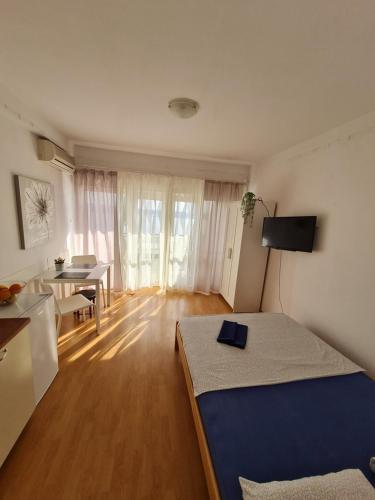 a bedroom with a bed and a table and a room with a table at Apartmani E&G in Dramalj