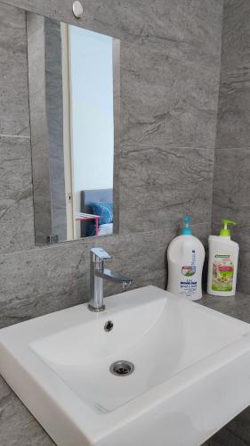 a white sink in a bathroom with a mirror at Mevin Woodsbury Suite Butterworth Penang in Butterworth