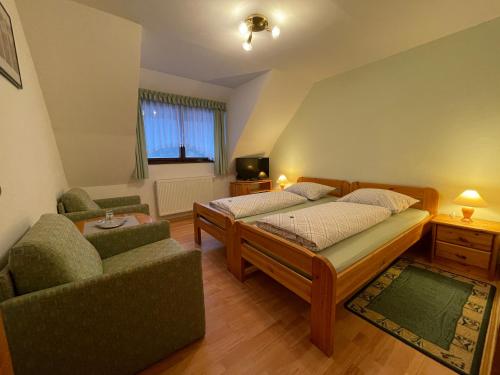 a bedroom with two beds and a couch and a tv at Waldhotel Zöbischhaus in Bad Reiboldsgrün