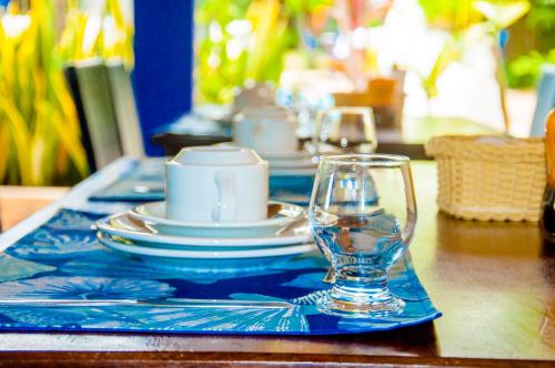 a table with plates and glasses on a blue table cloth at Pousada Arriba Pipa in Pipa