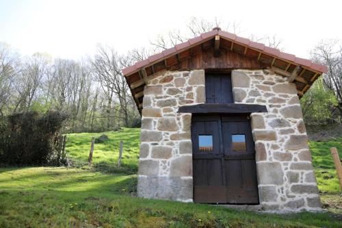 a small stone building with a wooden door at Le Pont de Livinhac in Decazeville
