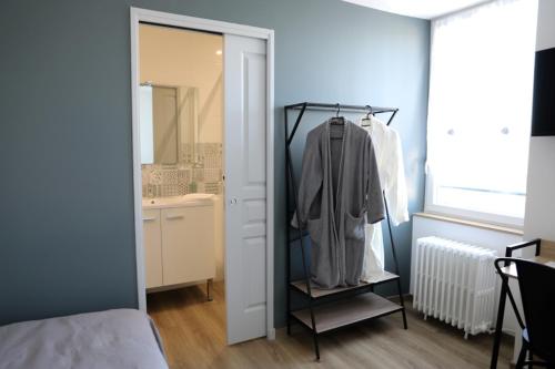 a bedroom with a closet with a sink and a mirror at Le Pont de Livinhac in Decazeville