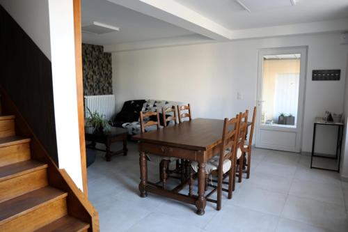 a dining room with a wooden table and chairs at Le Pont de Livinhac in Decazeville