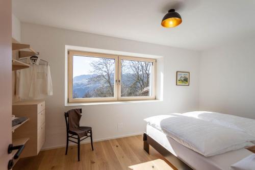 a bedroom with a bed and a desk and a window at Residence Villa Schlern in Fiè