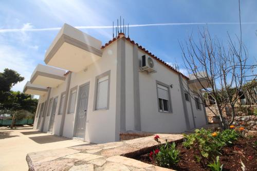 a small white building with a stone walkway at Sky Apartments in Sarandë