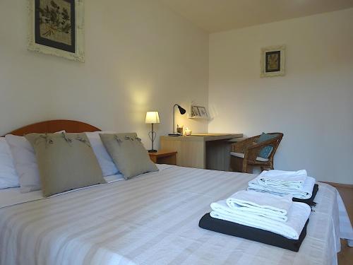 a bedroom with a bed with white sheets and a desk at Eco Apartments Kate in Suđurađ