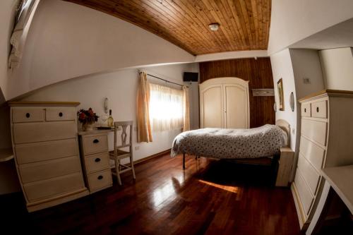 a bedroom with a bed and a dresser and a window at Albergo Generale Cantore - Monte Amiata in Abbadia San Salvatore