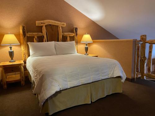 a bedroom with a large bed with two chairs at Elkwater Lake Lodge and Resort in Elkwater