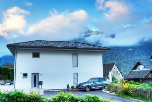 a white house with a car parked in front of it at Apartment Brigitte in Obertraun