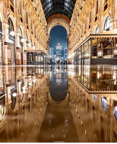 a large building with a reflection in the water at Villino Carla in Lipomo