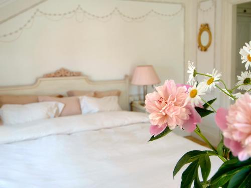 a bedroom with a bed with pink flowers in the foreground at Gripsholms Värdshus in Mariefred