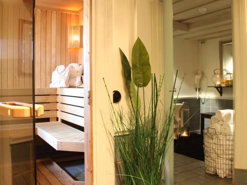 a bathroom with a plant in the corner of a room at Gripsholms Värdshus in Mariefred