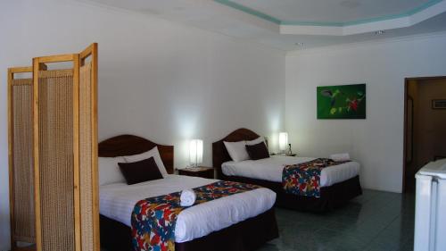 ein Hotelzimmer mit 2 Betten in einem Zimmer in der Unterkunft Hotel Costa Pacifica in Esterillos