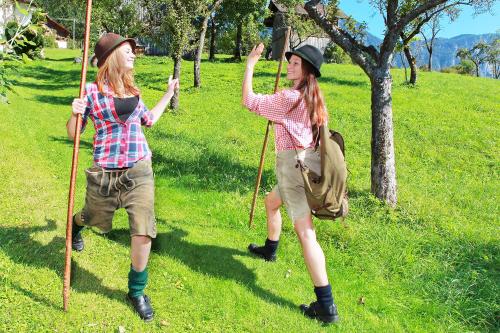 two young girls are standing on a grassy field with their sticks at Apartment Brigitte in Obertraun